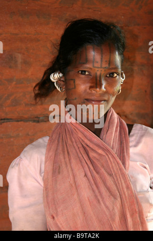 Giovani Kutia Kondh donna con la faccia del tatuaggio tradizionale e orecchini in argento, Orissa, India Foto Stock