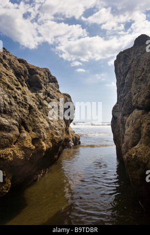 Ocean lavaggio tra le rocce su Playa Jaco Beach in Puntarenas Provincia di Costa Rica centrale. Foto Stock