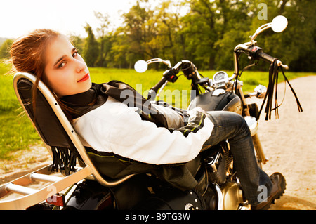 Giovane donna rilassante sulla moto Foto Stock