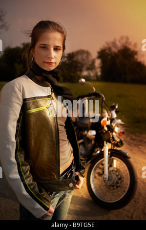 Giovane donna in posa la sera a moto Foto Stock