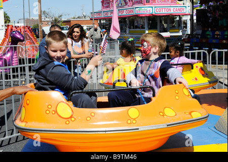 I bambini sulle giostre di Midway a Mardi Gras celebrazione nel Lago del Galles Centrale della Florida USA Foto Stock