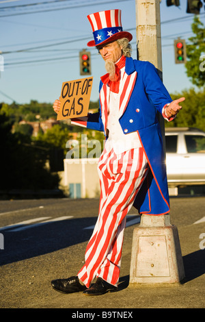 Lo zio Sam sul lato della strada tenendo un al di fuori del segno di Gas Foto Stock