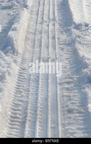 Sentieri della ruota di pneumatici nella neve Foto Stock