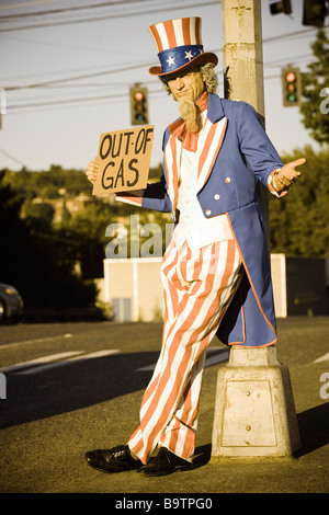 Lo zio Sam sul lato della strada tenendo un al di fuori del segno di Gas Foto Stock