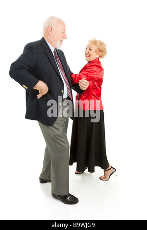 Felice coppia senior avente una grande time square dancing isolato su bianco Foto Stock