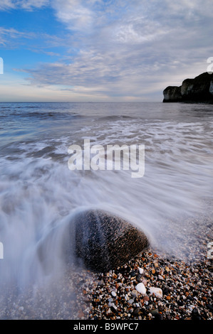 Una lenta esposizione cattura i pattern di acqua in passato un singolo rock in Thornwick Bay, Flamborough, nello Yorkshire, Regno Unito, Europa Foto Stock