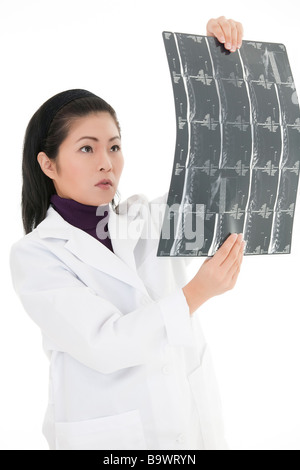 Bella asiatica medico la lettura di un MRI su sfondo bianco Foto Stock
