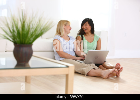 Due donne sedute con computer portatile Foto Stock
