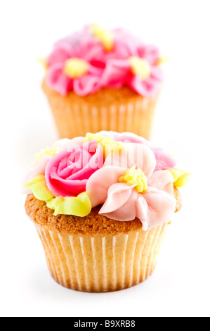 Fila di gustosi tortini con fiori di glassa Foto Stock