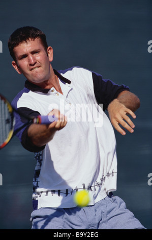 Maschio giovane giocatore di tennis in azione Foto Stock