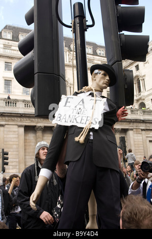 Manifestanti anarchico staging un finto impiccagione di un manichino vestito come un banchiere durante la lotta contro il capitalismo proteste in città Foto Stock