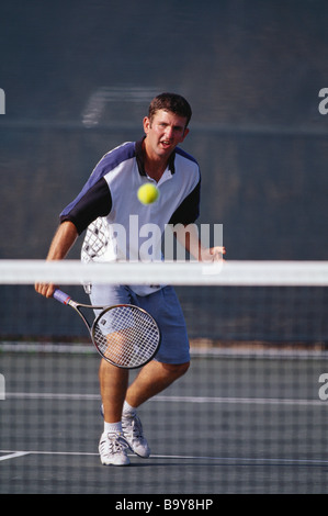 Maschio giovane giocatore di tennis in azione Foto Stock