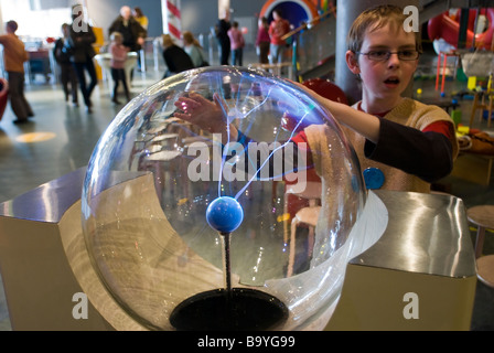 Ragazzo a sperimentare con una lampada al plasma al NEMO bambini's Science Museum di Amsterdam, Paesi Bassi Foto Stock