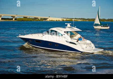 Sea Ray 43 Sundancer powerboat e barca a vela sul fiume in Florida USA Sea Ray Sundancer 43 Motoryacht und Segeboot auf einem Fluss Foto Stock