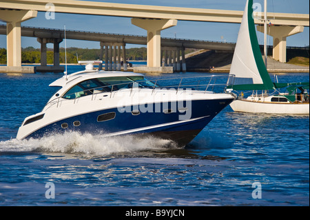 Sea Ray 43 Sundancer powerboat e barca a vela sul fiume in Florida USA Sea Ray Sundancer 43 Motoryacht und Segeboot auf einem Fluss Foto Stock