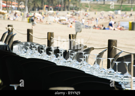 Bicchieri di vino capovolta in righe sul tavolo al ristorante sul mare Foto Stock