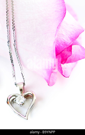 Cuore pendente con diamante con una rosa rosa Foto Stock