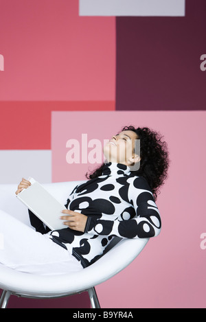 Donna godendo prenota, Pendente ritornare con gli occhi chiusi, sorridente Foto Stock