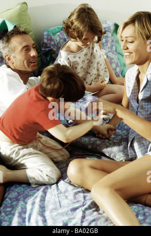 Famiglia giocando insieme a letto Foto Stock