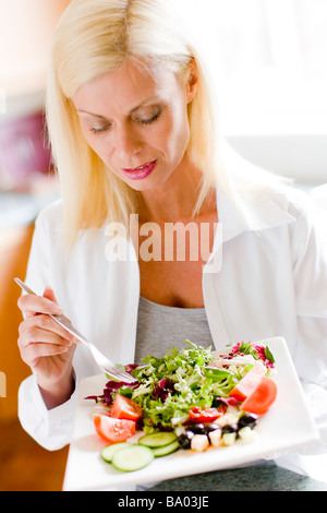 Ritratto di donna matura mangiare insalata Foto Stock