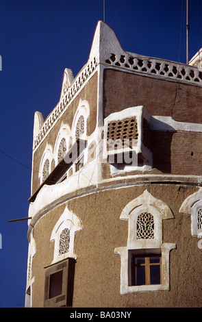 Stanza quadrata sulla parte superiore del Round Adobe Mattone di fango casa torre con finestre decorate, Sana'a o San'a, capitale Repubblica dello Yemen Foto Stock