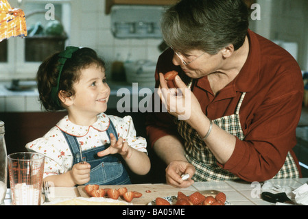 Nonna e nipote il taglio di fragole, sorridente ad ogni altro Foto Stock