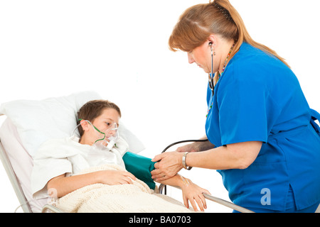 Little Boy in ospedale a guardare un infermiere prende la sua pressione del sangue Foto Stock