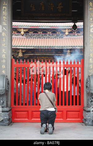 Donna orante al tempio Longshan, Taipei, Taiwan Foto Stock