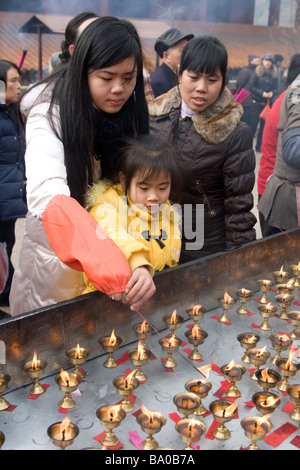 Illuminazione persone joss bastoni o di incenso e facendo offerte di incenso su Capodanno a un tempio in Cina Foto Stock