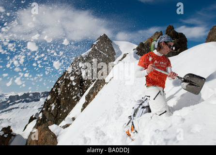 Sciatore scavando la neve in montagna, Chamonix, Francia Foto Stock