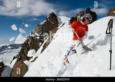 Sciatore scavando una buca nella neve in montagna (neve analisi / pericolo di valanghe di valutazione) Foto Stock