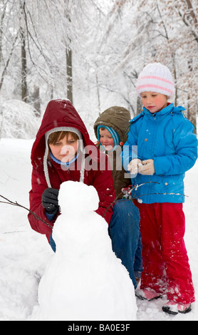 La famiglia felice (madre con il piccolo ragazzo e ragazza) in inverno il parco della città Foto Stock
