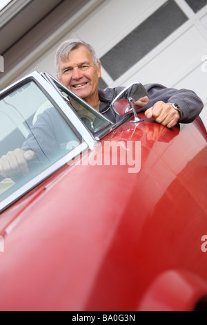 Senior uomo seduto in auto convertibili Foto Stock