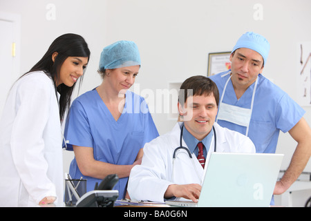 Il personale medico guardando il computer portatile Foto Stock