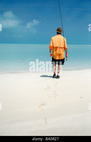 Un pescatore a mosca passeggiate per i cappelli per bonefishing nelle isole exuma, BAHAMAS Foto Stock