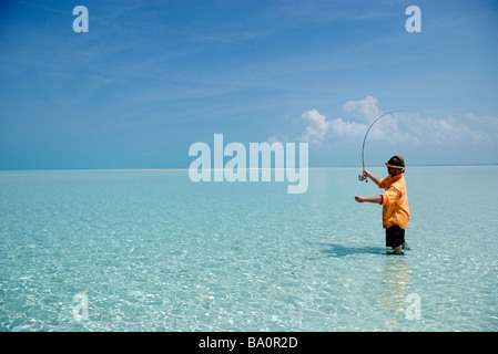 Un pescatore a mosca calchi di bonefish nelle isole exuma appartamenti Foto Stock