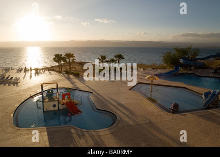 Una vista fuori dal Mar Morto Spa Beach Hotel oltre le piscine e il Mar Morto al tramonto, Giordania Foto Stock