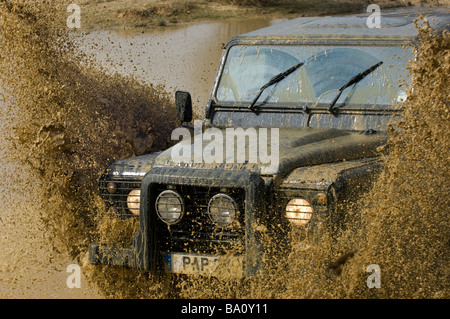 Un Land Rover Defender 90 guidando attraverso un diluvio Foto Stock