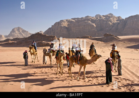 I turisti a cavallo di cammelli nel deserto, Wadi Rum, Giordania Foto Stock