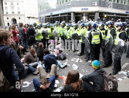 I manifestanti seduti davanti di polizia al G20 proteste a Londra Foto Stock