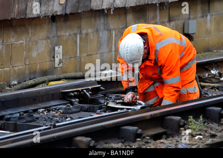 Operaio ferroviario riparazione di punti su una linea ferroviaria, Gran Bretagna, Regno Unito Foto Stock