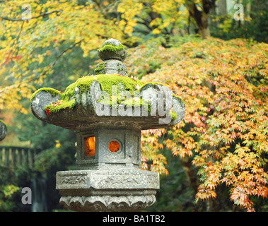 Antica lanterna di pietra ricoperta di verde muschio Foto Stock