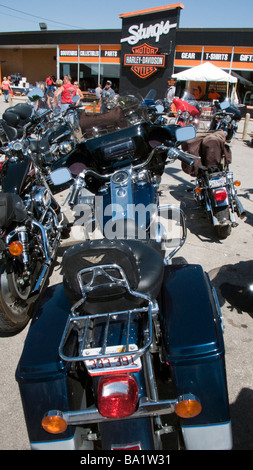 Punteggi di moto parcheggiate fuori Sturgis Harley Davidson rivenditore nel corso annuale di moto raduno del South Dakota USA Foto Stock