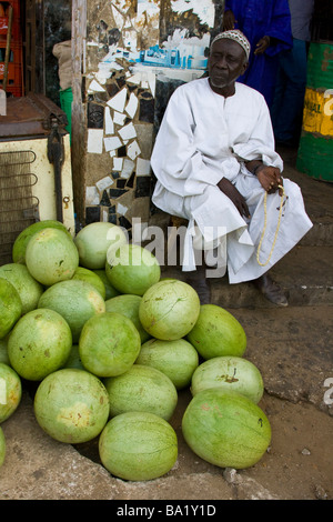 Uomo musulmano contando i grani di preghiera e di vendita di angurie a Dakar in Senegal Foto Stock