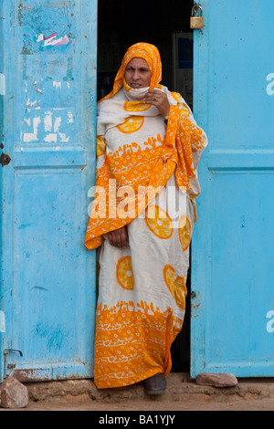 Donna musulmana in piedi in un portale in Ayoun El Atrous in Mauritania Africa occidentale Foto Stock