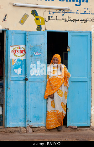 Donna musulmana in piedi in un portale in Ayoun El Atrous in Mauritania Africa occidentale Foto Stock