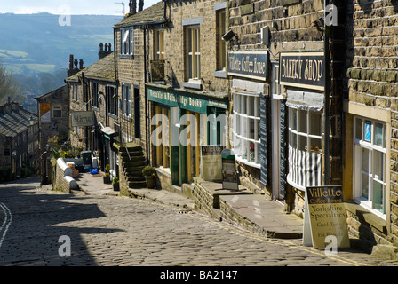 La strada principale lastricata in pietra in Haworth, West Yorkshire, Inghilterra, Regno Unito Foto Stock