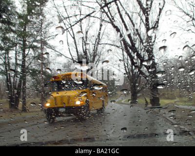 Quando si incrociano altri bus di scuola in un giorno di pioggia. Foto Stock