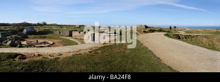 Una vista panoramica della Point du Hoc sito in Normandia. Due persone a piedi lungo il percorso. Gun emplacement in primo piano. Foto Stock