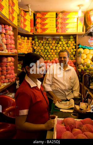 Una giovane donna e un uomo di lavorare in una stalla di frutta in Brigade Road nel centro di Bangalore, India. Foto Stock